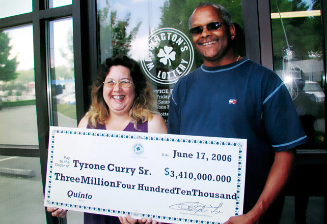 Tyrone Curry and His Wife Michele posing with the ceremonial copy of the check
